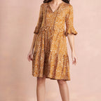 Woman wearing a patterned dress on a beige background