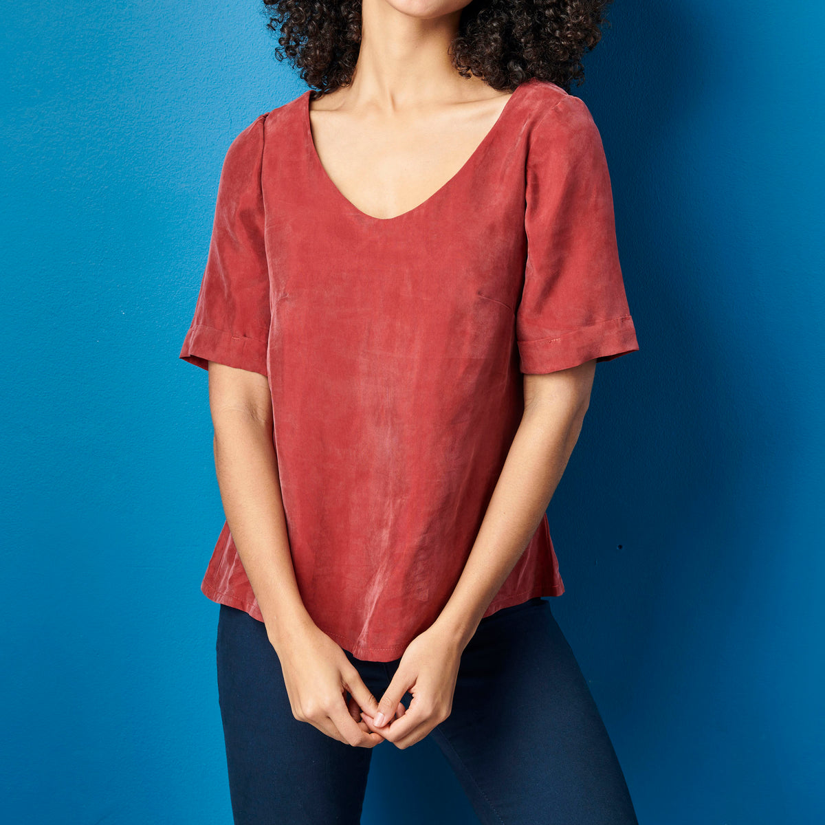 Person wearing a red shirt against a blue background