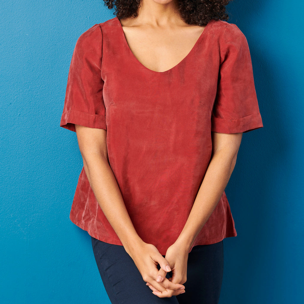 Person wearing a red shirt against a blue background